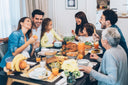 Big happy family eating nutritious food for dinner while discussing, “Do wounds heal faster in a caloric surplus?”