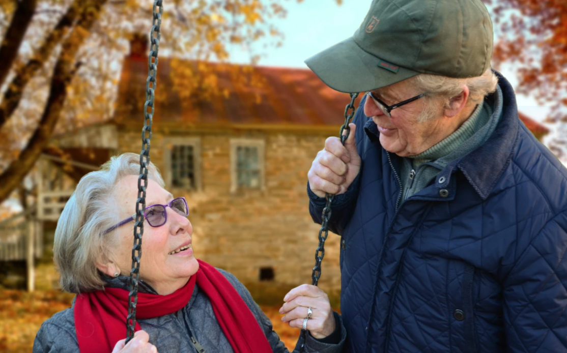 Happy loving elderly couple are at their outdoor swing talking about the best diet for arthritis