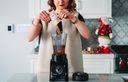 Woman pouring hydrolyzed collagen protein powder, one of the many types of collagen, into a blender