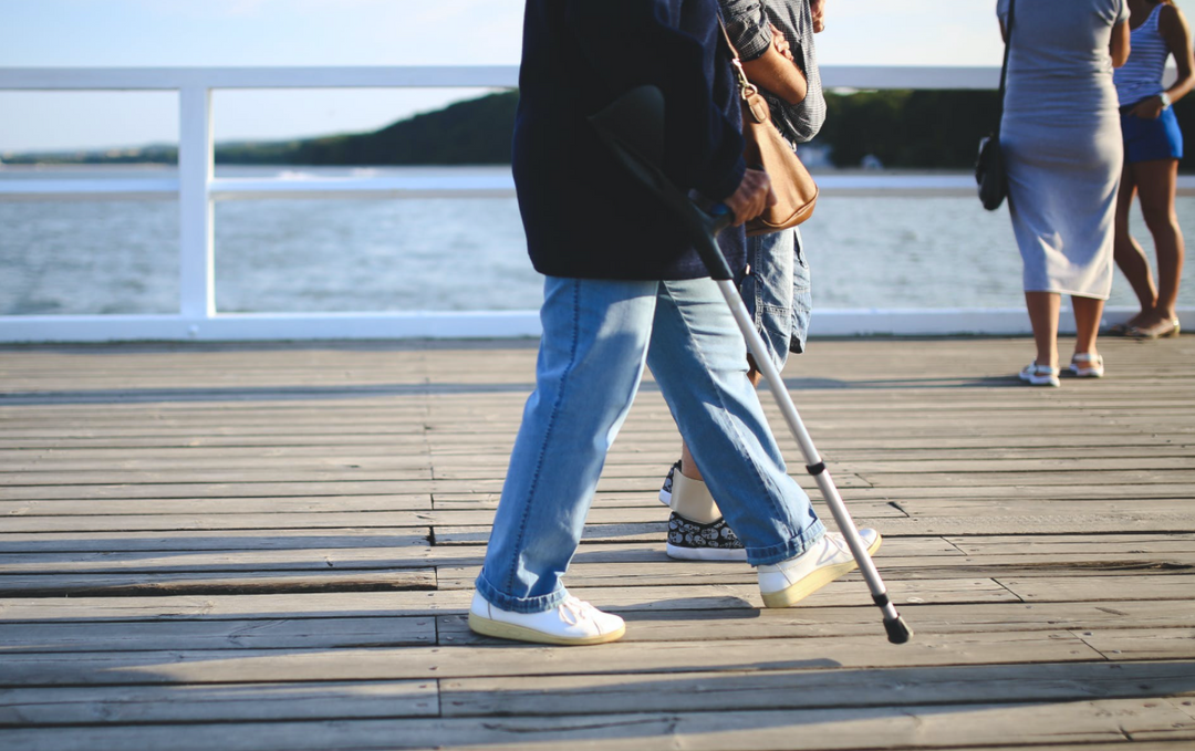 Patient walking on a boardwalk with a cane to stay active post surgery as part of her wound care solutions