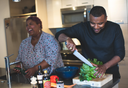 Happy wife asking her registered dietitian husband, “How much collagen should I take?” while preparing veggies for bone broth