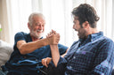 Senior father and adult son bonding together and talking about: “At what age does healing slow down?”