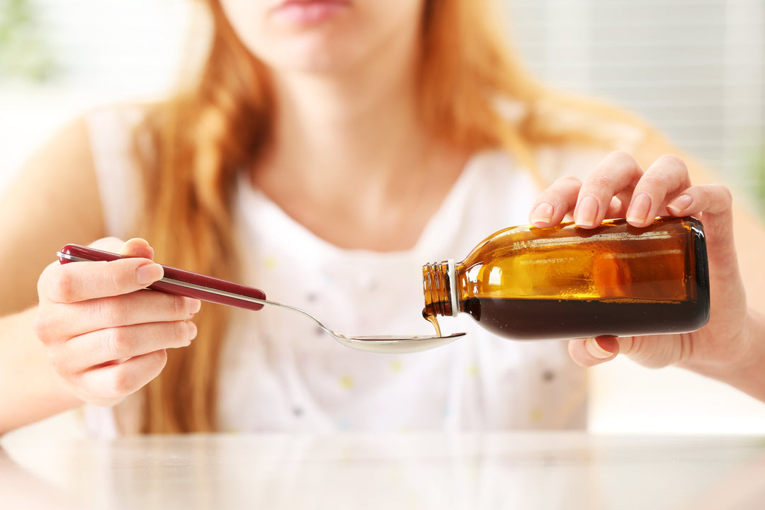 Woman pouring liquid bariatric vitamins onto a spoon