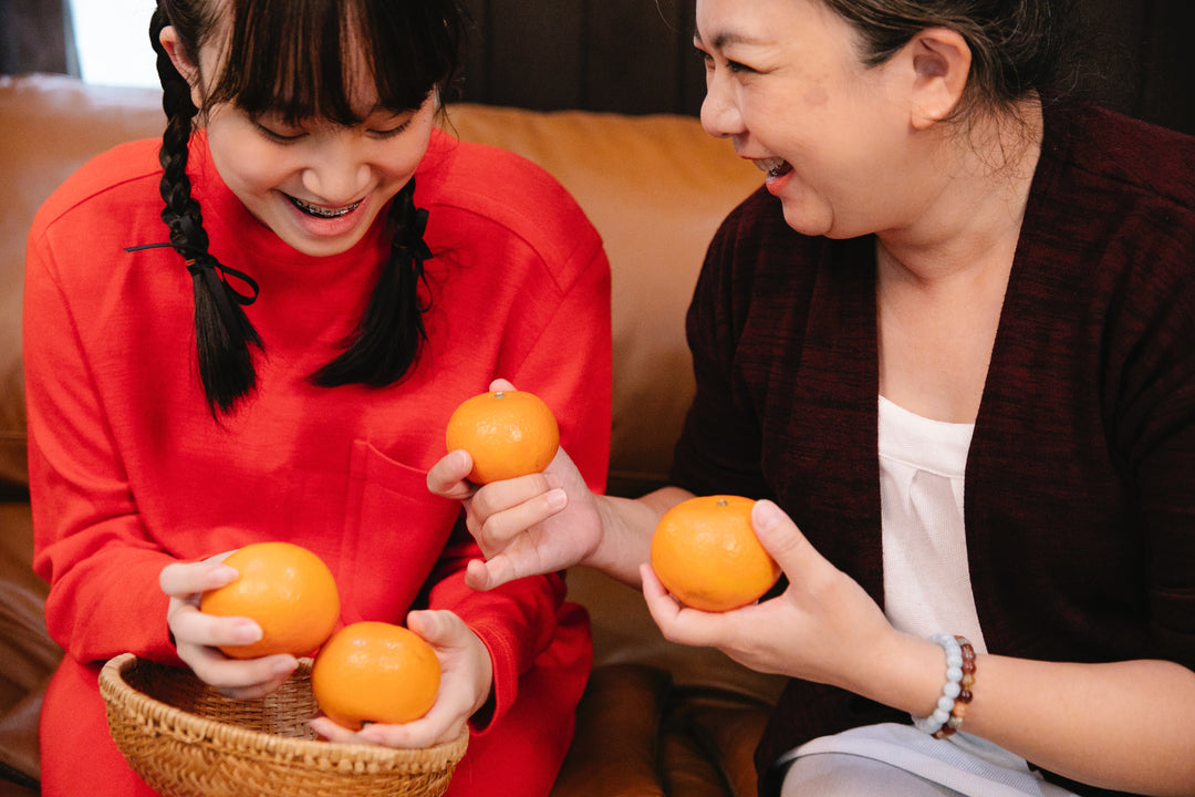 Mother and daughter holding oranges for the longevity diet