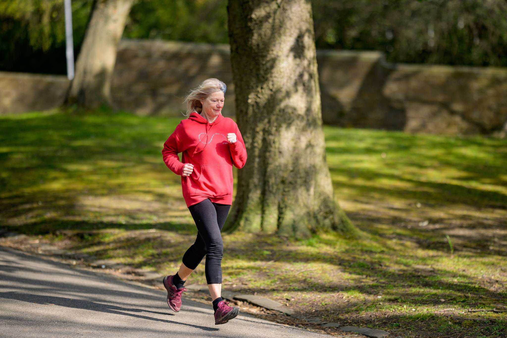 Senior woman running at a park to increase collagen for joints