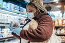 Health conscious woman, who knows how to read nutrition labels, is checking the information of a product in a supermarket