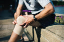 Male patient lightly massaging his knee to speed up injury recovery