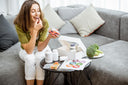 Young woman on a gray sofa taking vitamins for wound healing after surgery