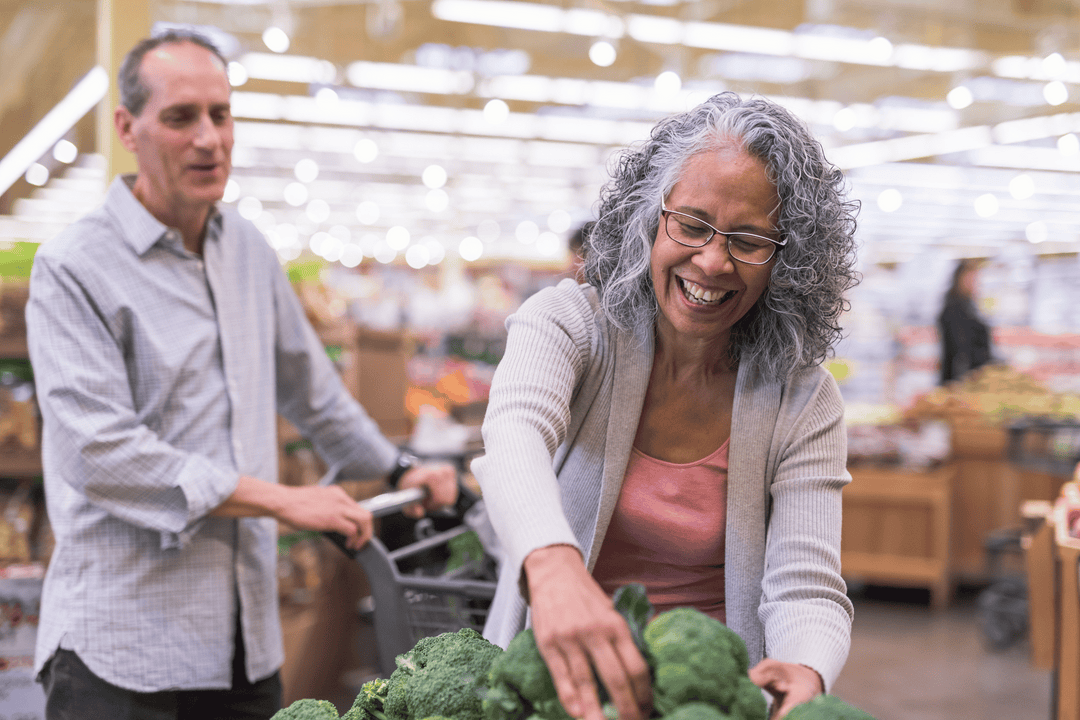 Senior couple grocery shopping together while talking about "can collagen cause heart problems?"