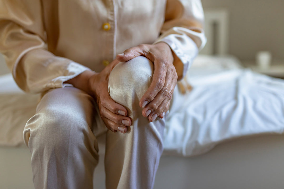 Woman holding her painful knee while thinking of the possible causes of her knee pain