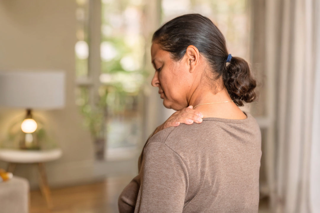 Woman clutching her shoulder while pondering the cause of shoulder pain