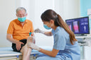 Physiotherapist treating a man's chronic knee pain