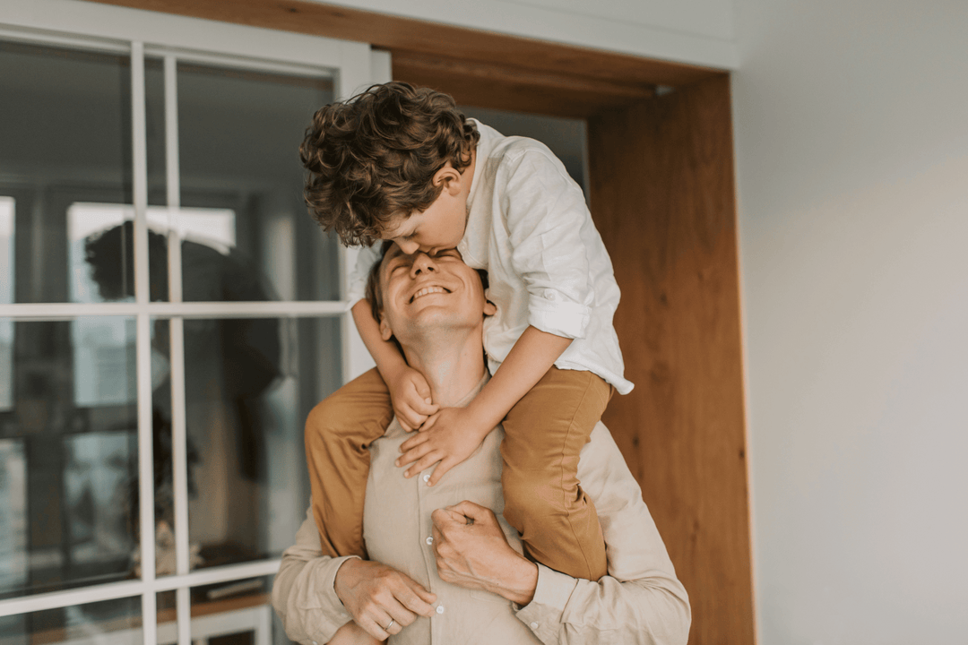 Man effortlessly carrying his son on his shoulders - one of the collagen benefits for men