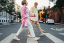 Happy elderly couple who has incorporated collagen for knees into their diet is crossing on a pedestrian lane while holding hands