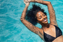 High-angle view of black woman relaxing in the water with closed eyes for hip arthritis treatment