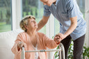 A physiotherapist assisting an elderly patient to prevent her from having hospital-acquired pressure injuries