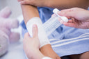 Young girl having bandage applied to her arm—one of the tricks for how to heal scabs fast