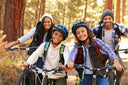 Parents with two kids cycling through fall woodland as a solution to "how to prevent knee pain"