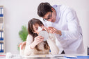 Surgeon giving aftercare tips, which includes supplements to reduce swelling after plastic surgery, to a patient who went through rhinoplasty