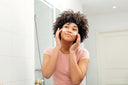 Young woman applying topical collagen on her skin