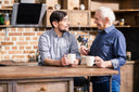 Father and son drinking coffee with collagen protein while talking about what to take for knee pain