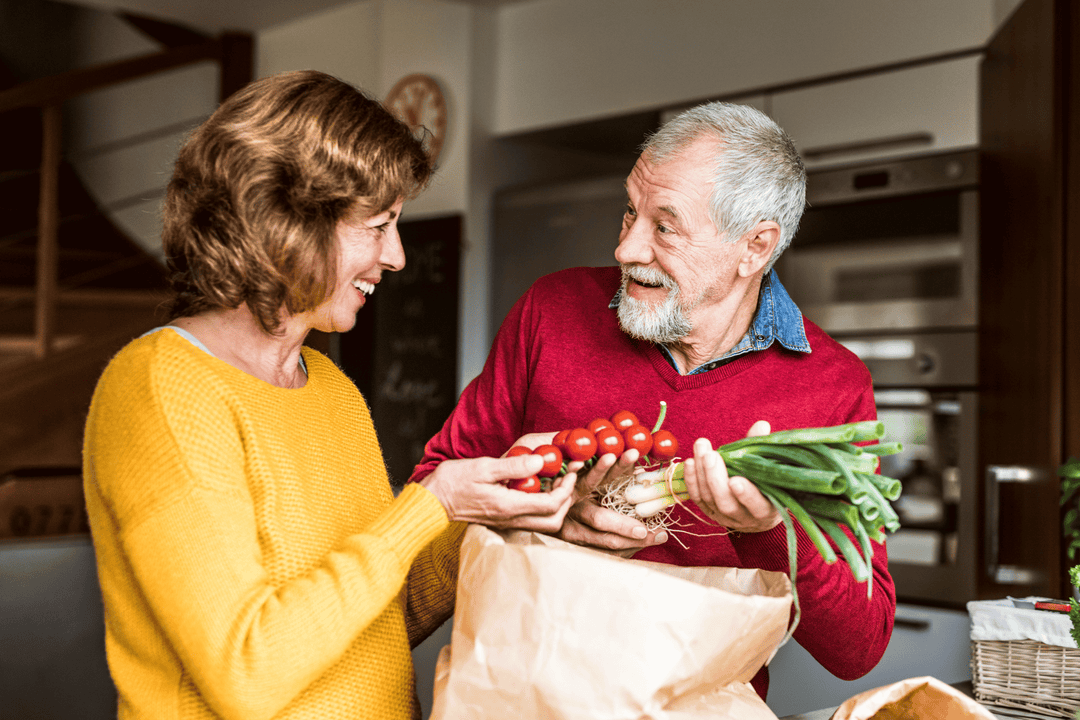 A senior couple prepares a meal rich in vitamin C, to complement their daily collagen protein supplement